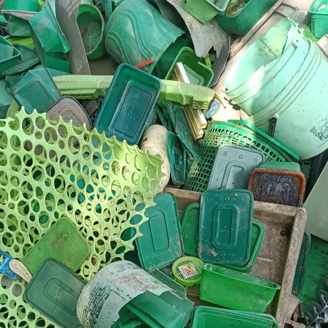 Pile of sorted green plastic containers, baskets and buckets